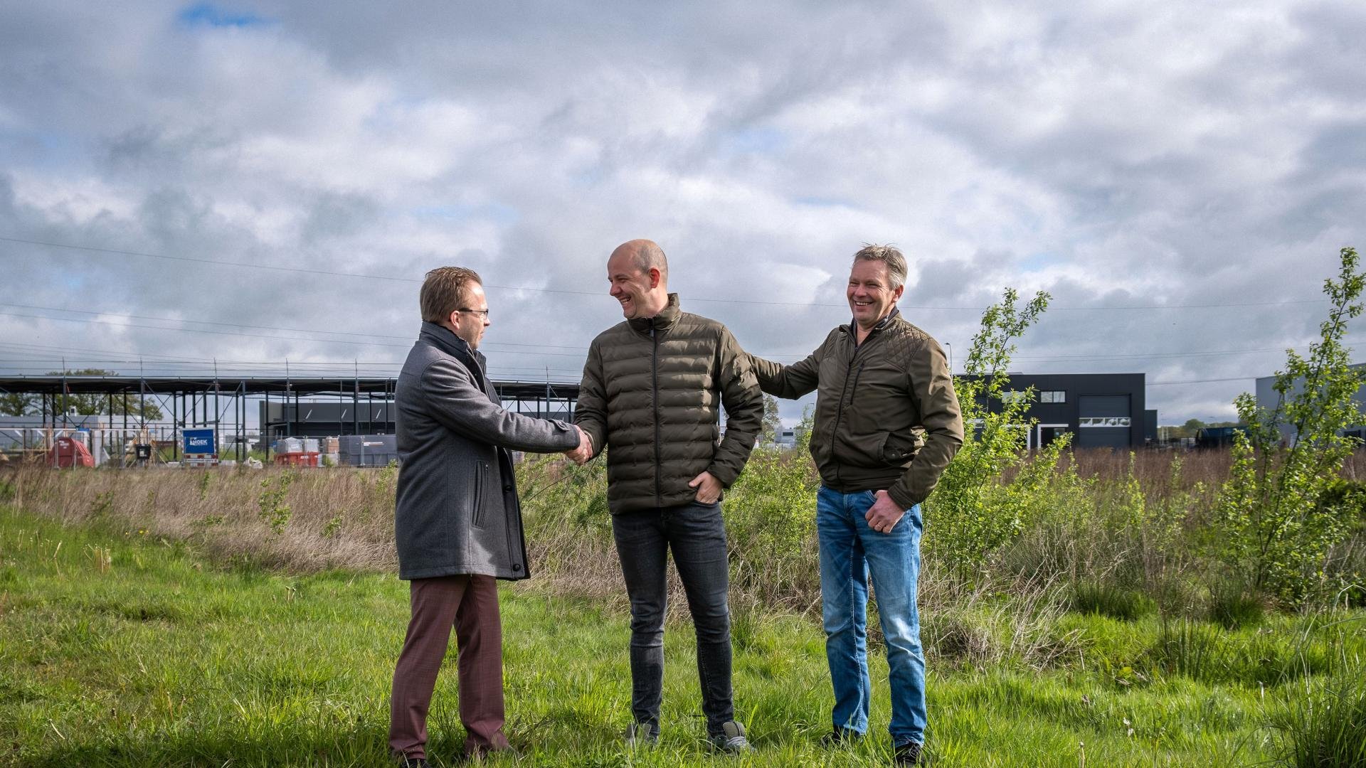 Wethouder Alexander Kreule feliciteert Rick Spijkerboer van FlexiblePlus en Jos Jansman van Current Connect met de aankoop van een bouwkavel op de Zegge VII in Raalte